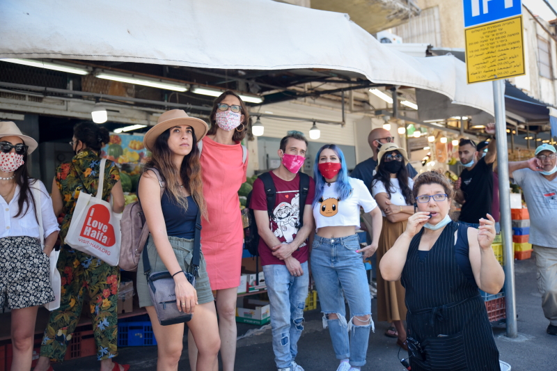 משפיענים במסכות קורונה בתחנת אוטובוס בשוק